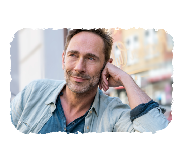 Leben mit PV und MF Ein Mann, der seinen Kopf in die Hand stützt und lächelt.