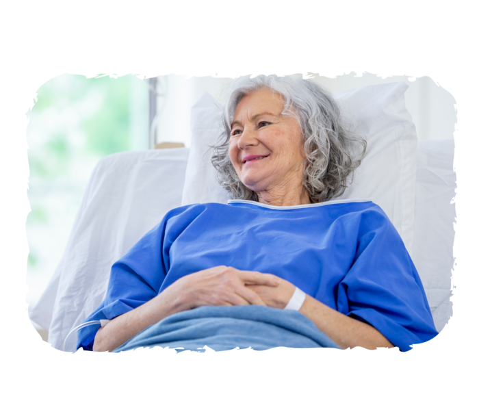 FL: Therapie Eine ältere Person erhält eine Infusion und lächelt.