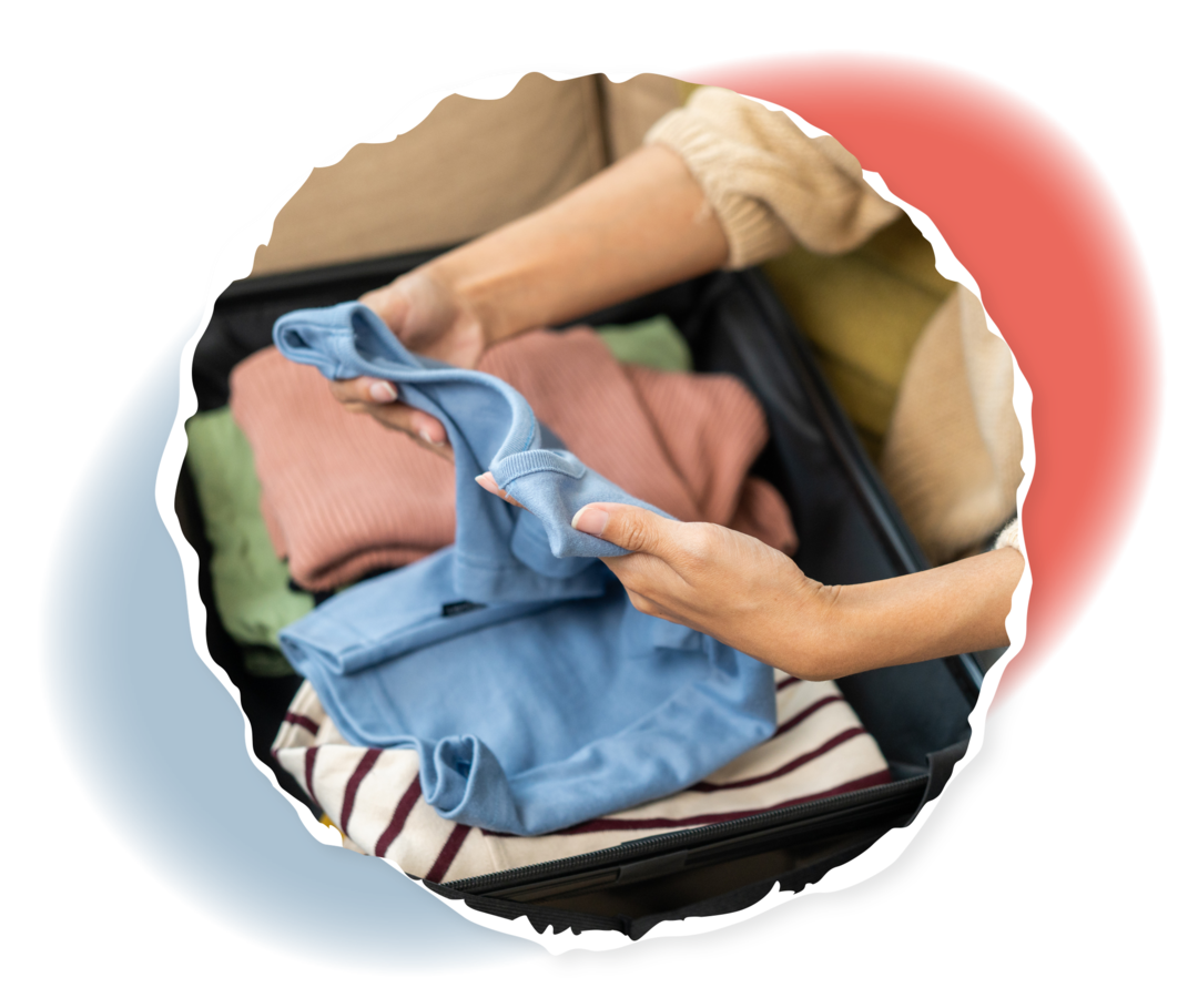 ALL: Kliniktasche packen Eine Frau packt Kleidungsstücke in einen Koffer.